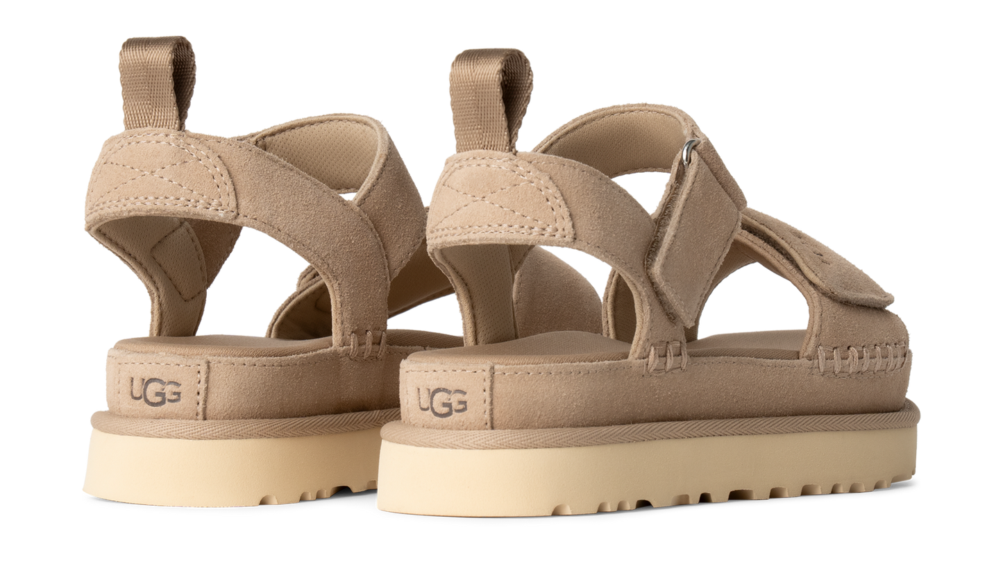 Two beige platform sandals with adjustable velcro straps and UGG logo on the heel.