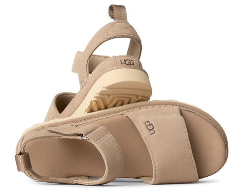 Two tan sandals with elastic back straps and wedge soles, UGG logo visible on the side.
