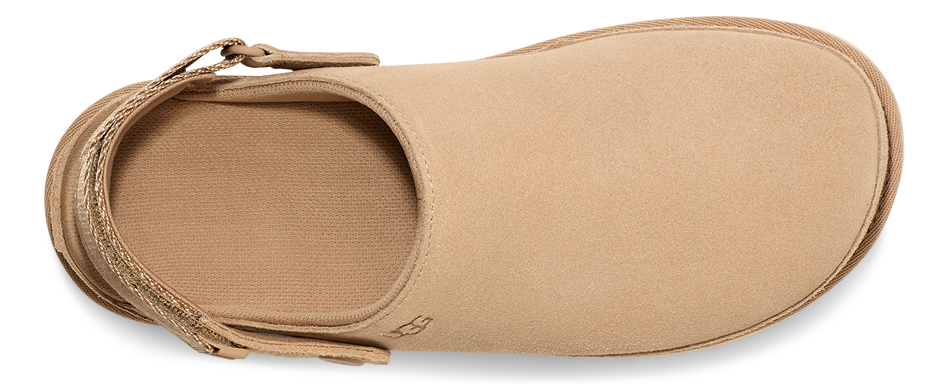 Tan clog-style shoe with adjustable strap and closed toe.