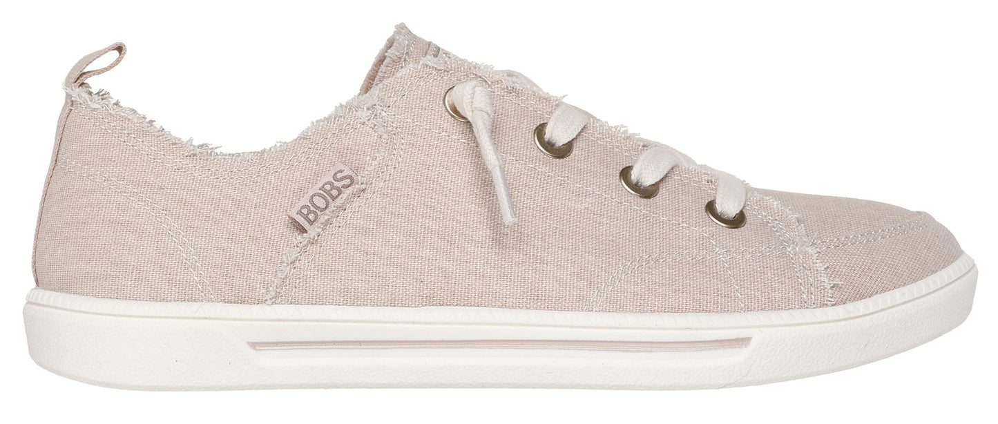 A slip-on sneaker with a white sole, and tan canvas upper with faux laces.
