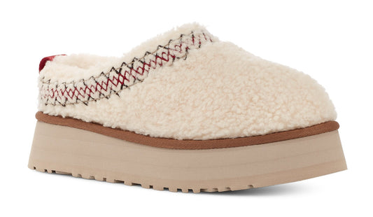 Off-white furry slipper with red and black stitching on the top edge, set on a thick, light brown platform sole.