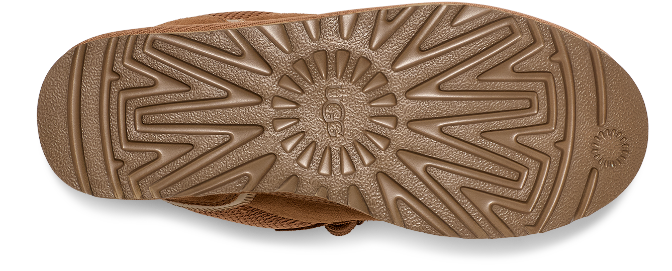 A close-up shot of the shoe sole. It's patterned with radial and zig-zag designs around the brand logo.