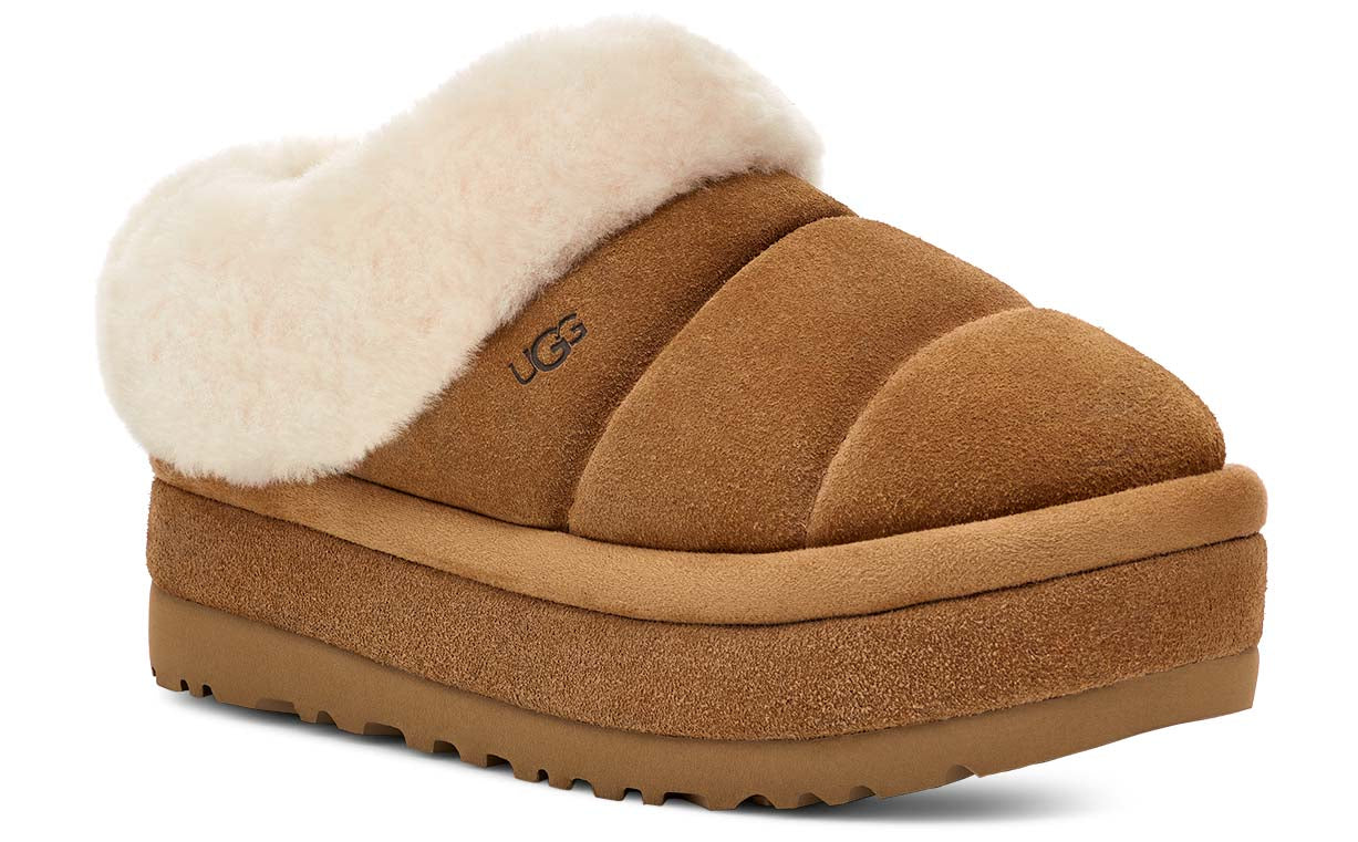Brown suede platform slipper with white faux fur trim and the word 'UGG' on the side.