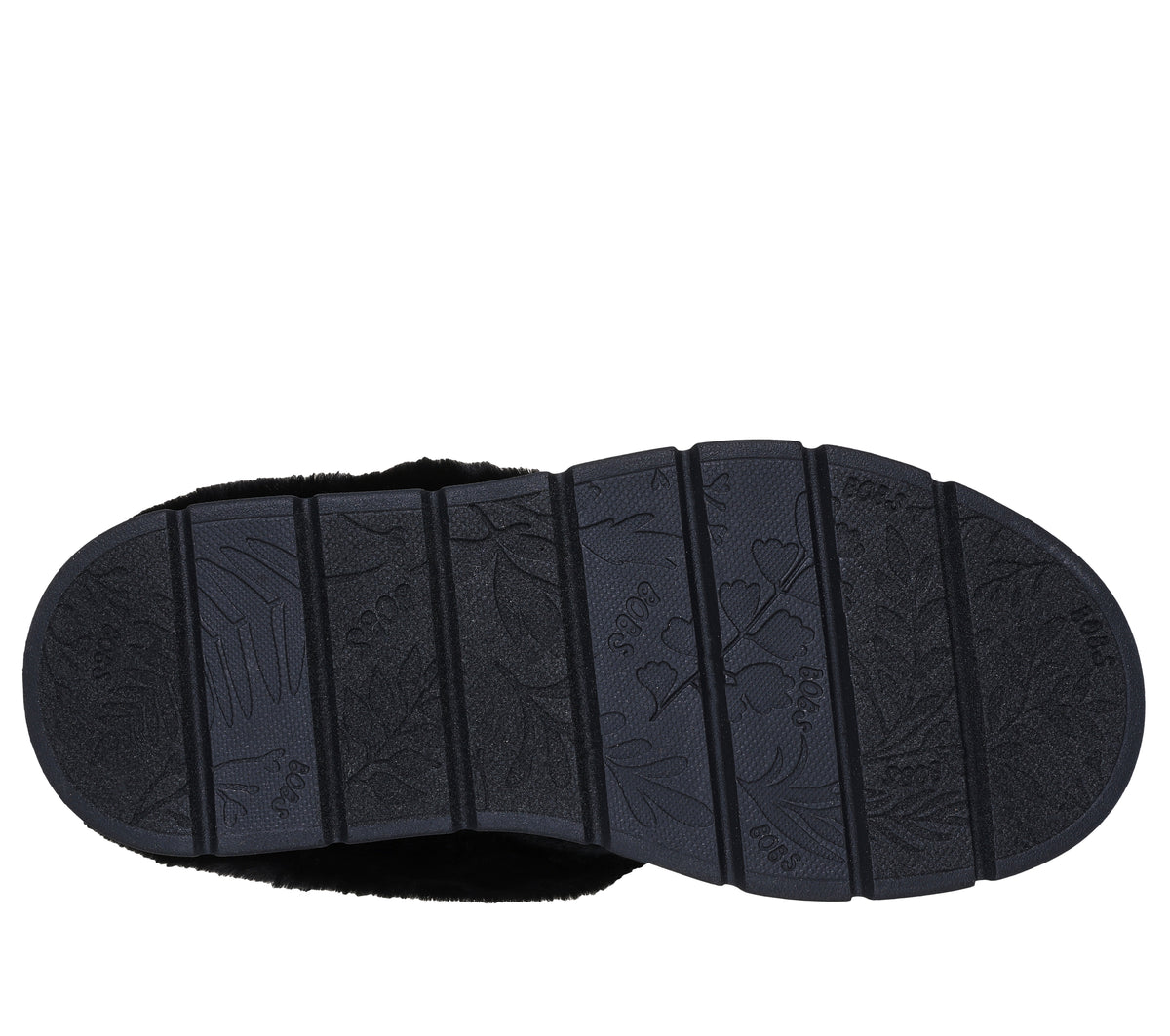 Close-up of the patterned black sole of a slipper.