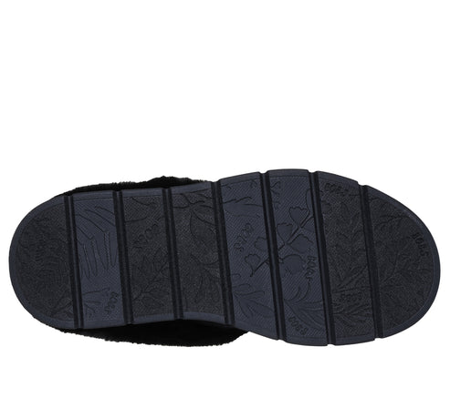 Close-up of the patterned black sole of a slipper.