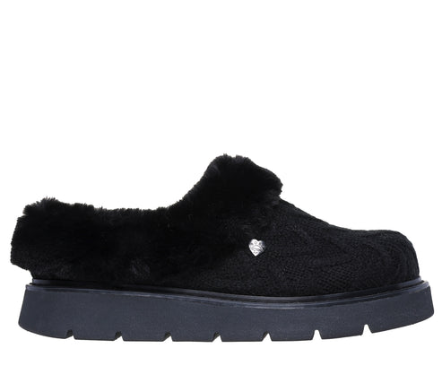 A black slip-on shoe with fuzzy uppers and a black lug sole.
