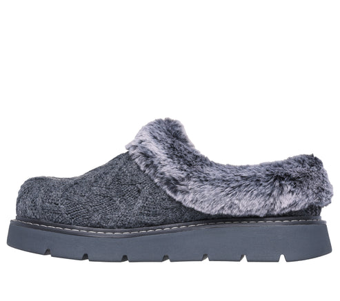 Side view of a gray, cable-knit mule with faux fur trim and a platform sole.