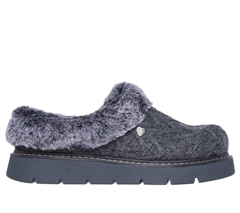 Charcoal furry clog with lug sole and silver dog paw emblem.