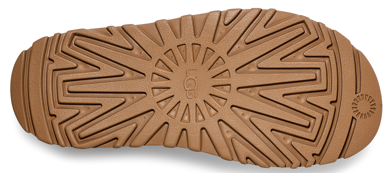 Close-up of the sole of a light brown shoe with the word "UGG" in the center of a circular pattern.