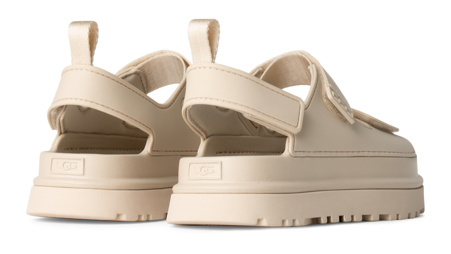 A pair of platform sandals in cream color with adjustable velcro strap.