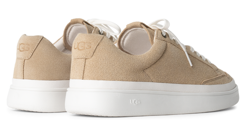 Low-profile, tan suede sneakers with white laces and thick white soles.
