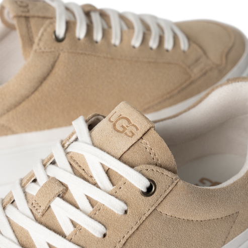 Low-top suede sneaker with the logo "UGG" on the tongue and white laces.