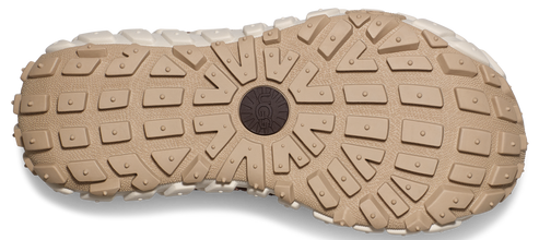 The outsole of a light brown shoe features a pattern of rectangular and triangular treads with circular details in the center.