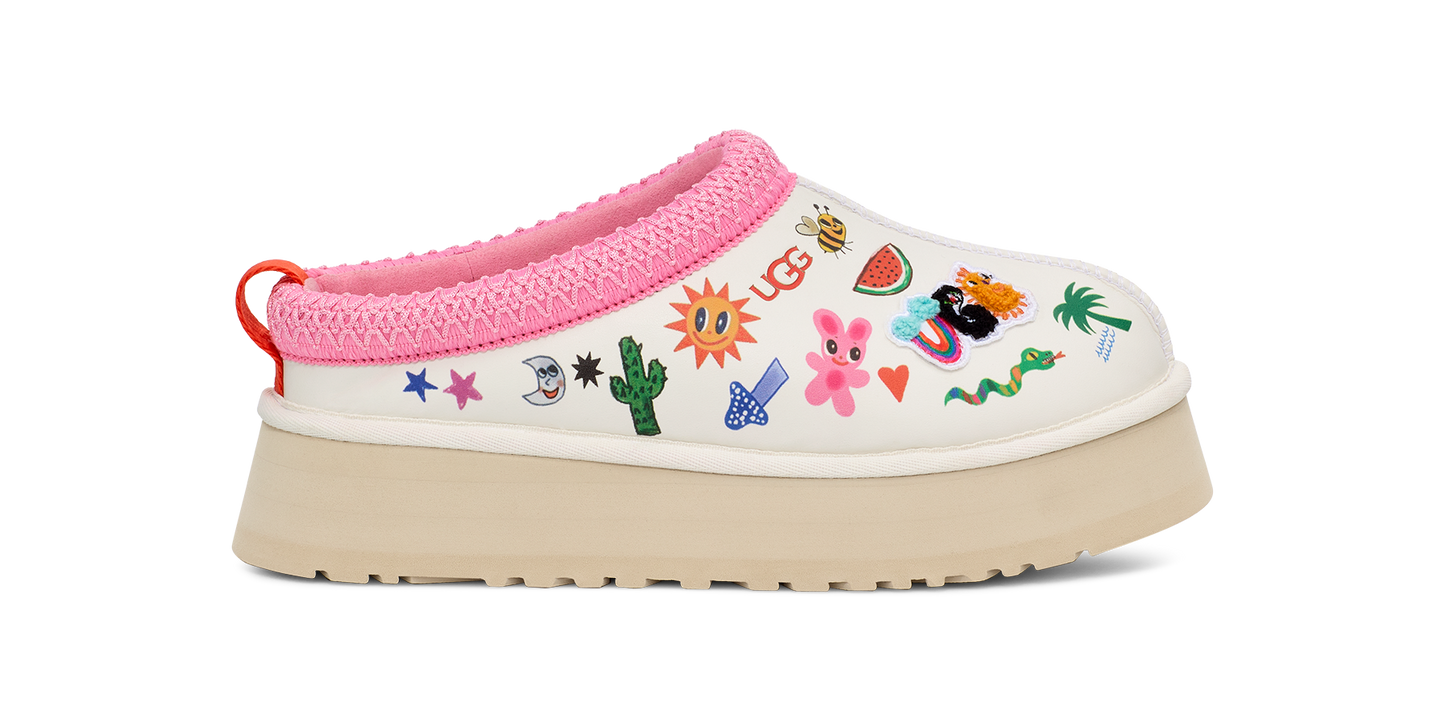 White clog shoe with pink trim, multi-colored decorative patches and a tan platform sole.