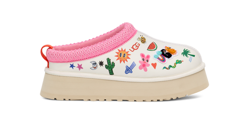 White clog shoe with pink trim, multi-colored decorative patches and a tan platform sole.