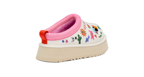 Slip-on shoe with colorful cartoon drawings, pink trim, and thick sole.