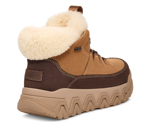 Side view of a brown UGG boot with a tan platform sole and a cream-colored sheepskin lining.