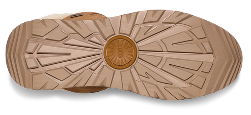 Sole of a shoe with intricate radial and linear treads, featuring a circular logo at the center.