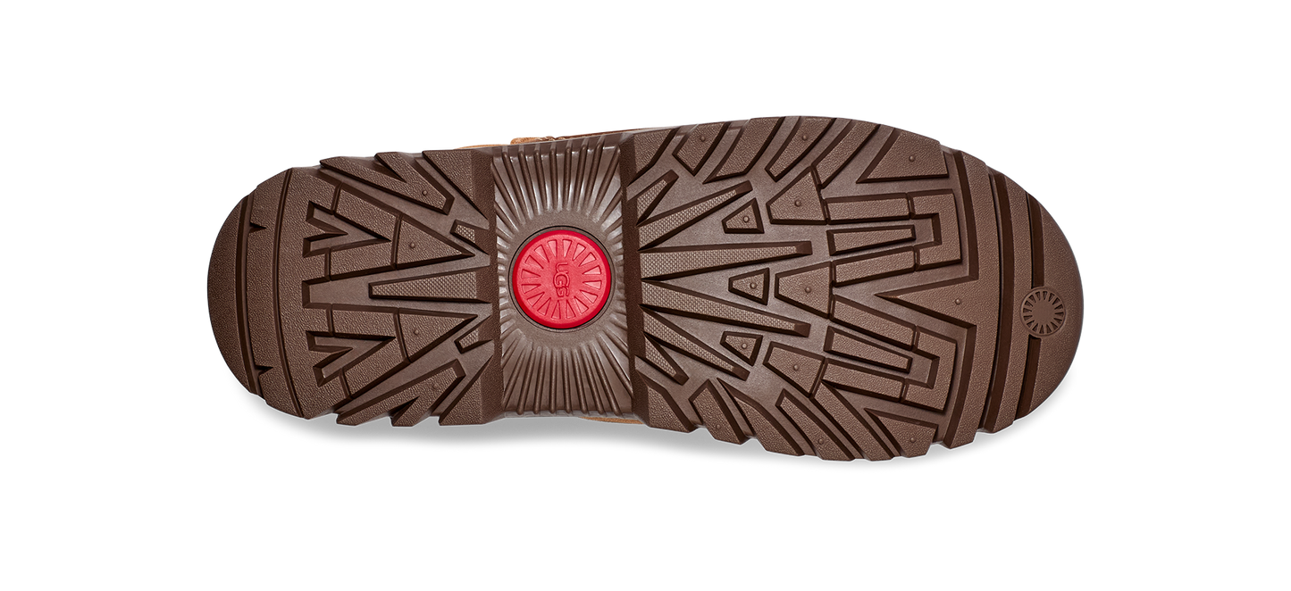 Bottom of boot with geometric treads and circular logo in center.