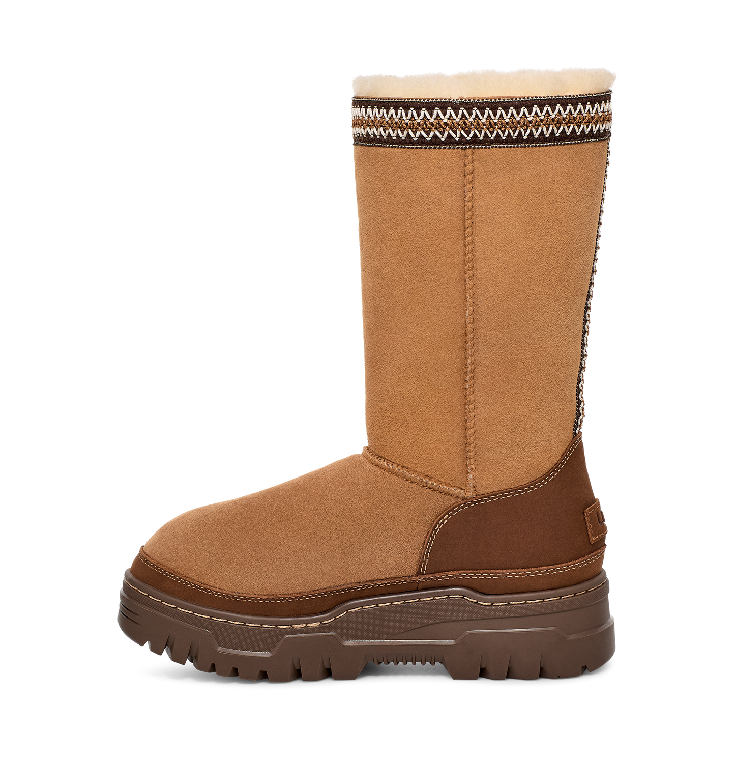 Tall, tan suede boot with a thick brown sole and a decorative zigzag pattern at the top.