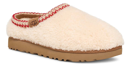 Slip-on house shoe with cream-colored plush upper, red and beige trim, tan sole and the letters UGG visible on the insole.