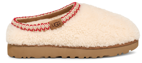 A white UGG slipper with red and white trim around the opening and a tan sole.