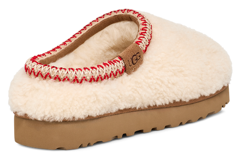 Slip-on slipper with off-white fleece upper, red and cream stitching around the collar, and a brown platform sole, showcasing a tan logo tag.
