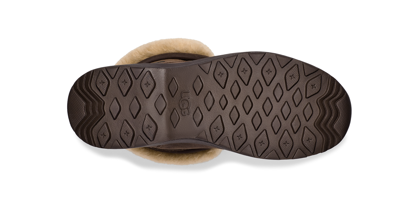 Bottom view of a boot with brown patterned sole and light-colored fur lining.