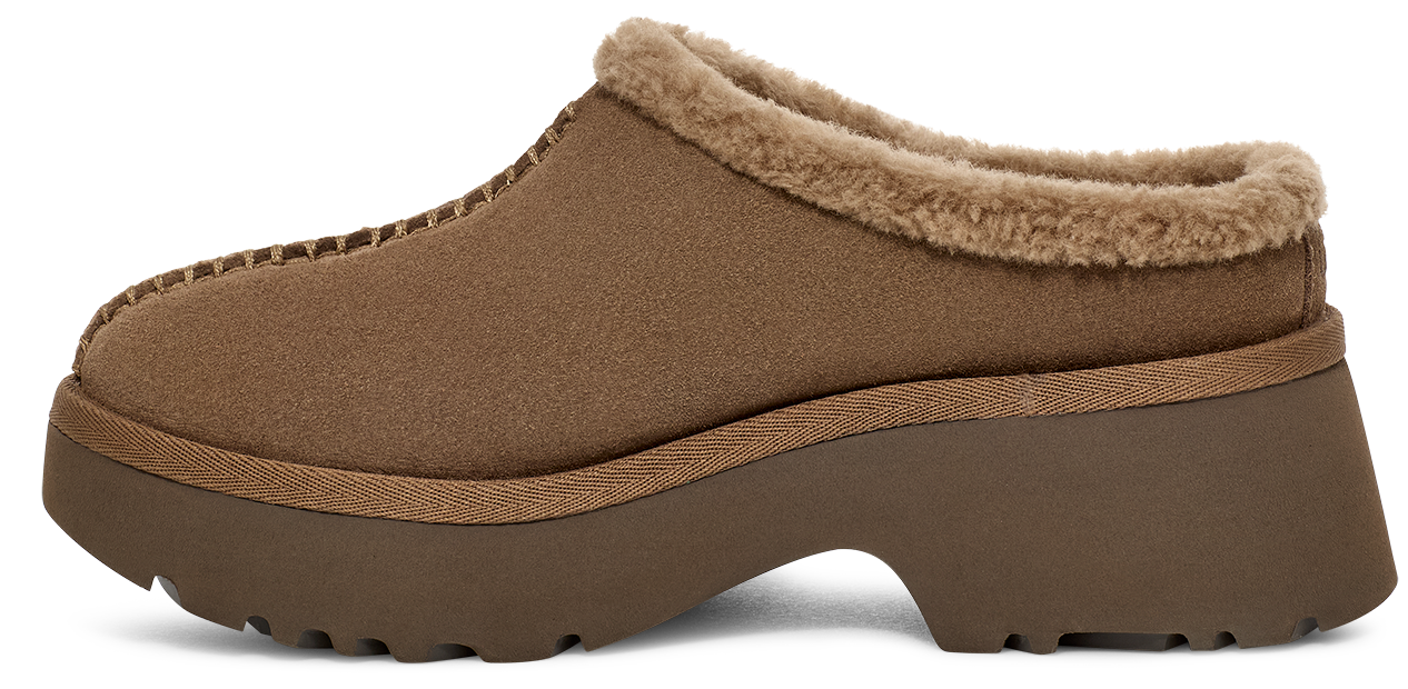 Side view of a slip-on shoe with a brown suede-like upper and a thick lug sole, featuring a faux fur trim around the opening.