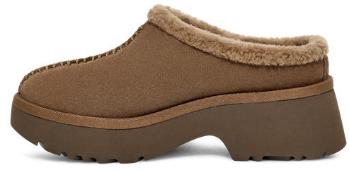 Side view of a slip-on shoe with a brown suede-like upper and a thick lug sole, featuring a faux fur trim around the opening.