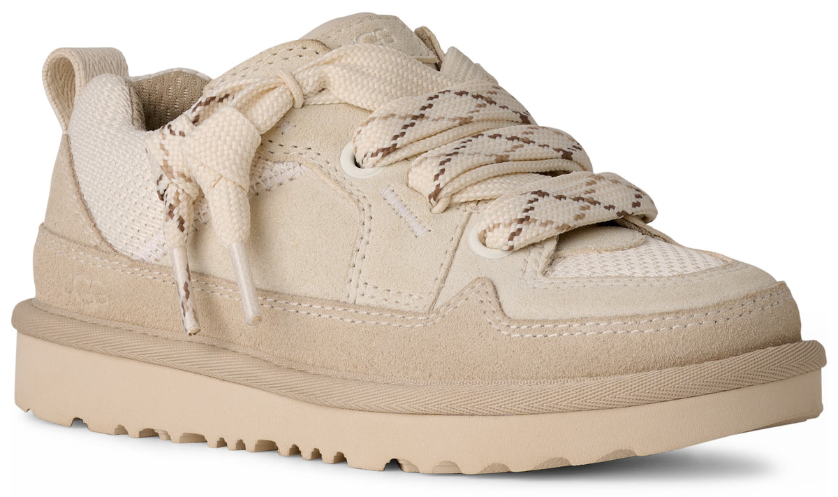 Low-top sneaker with suede trim, thick laces, and a notched beige sole.