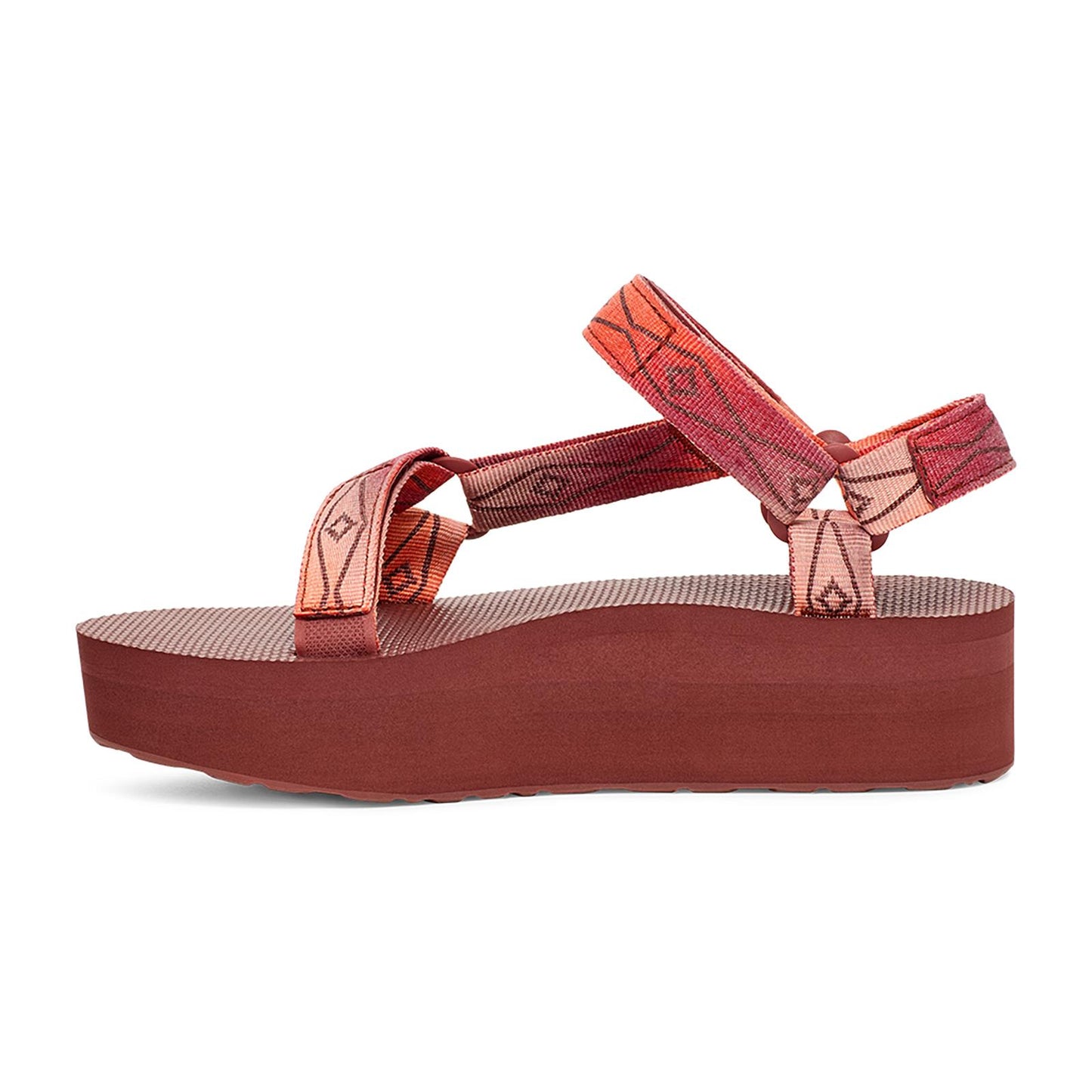 Platform sandal with reddish-brown sole and geometric patterned straps.