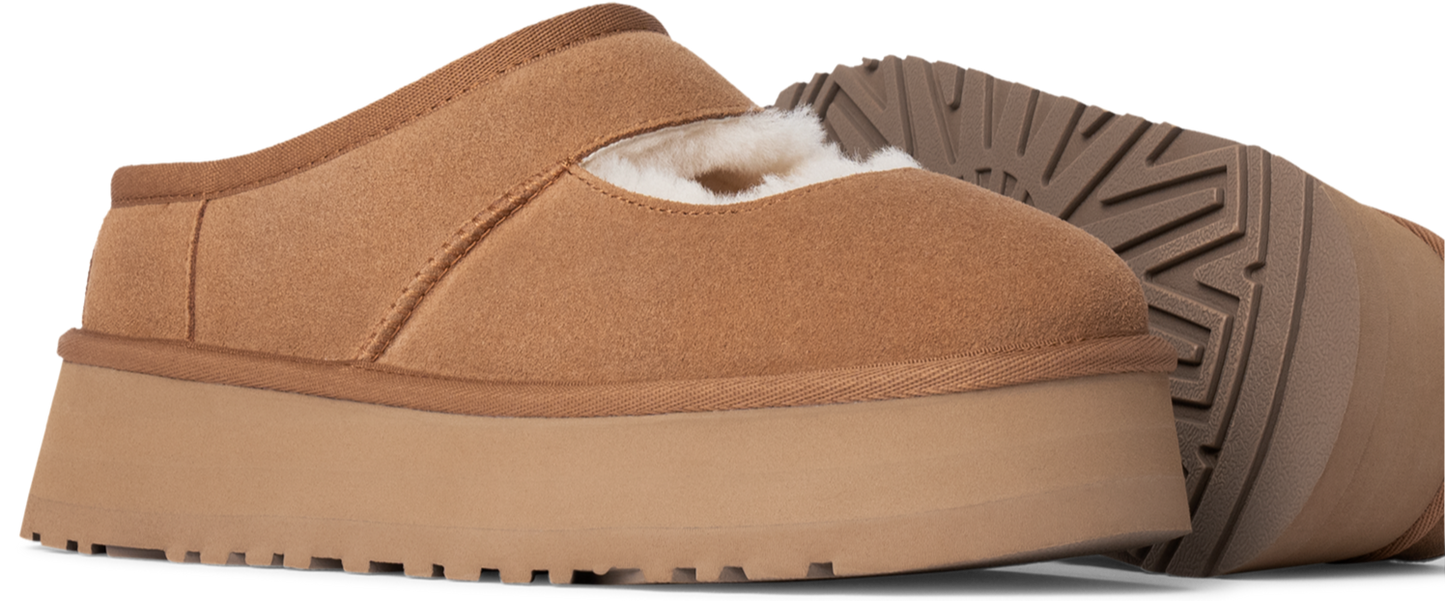 tan-colored slip-on shoe with a fluffy interior and a thick, flat sole