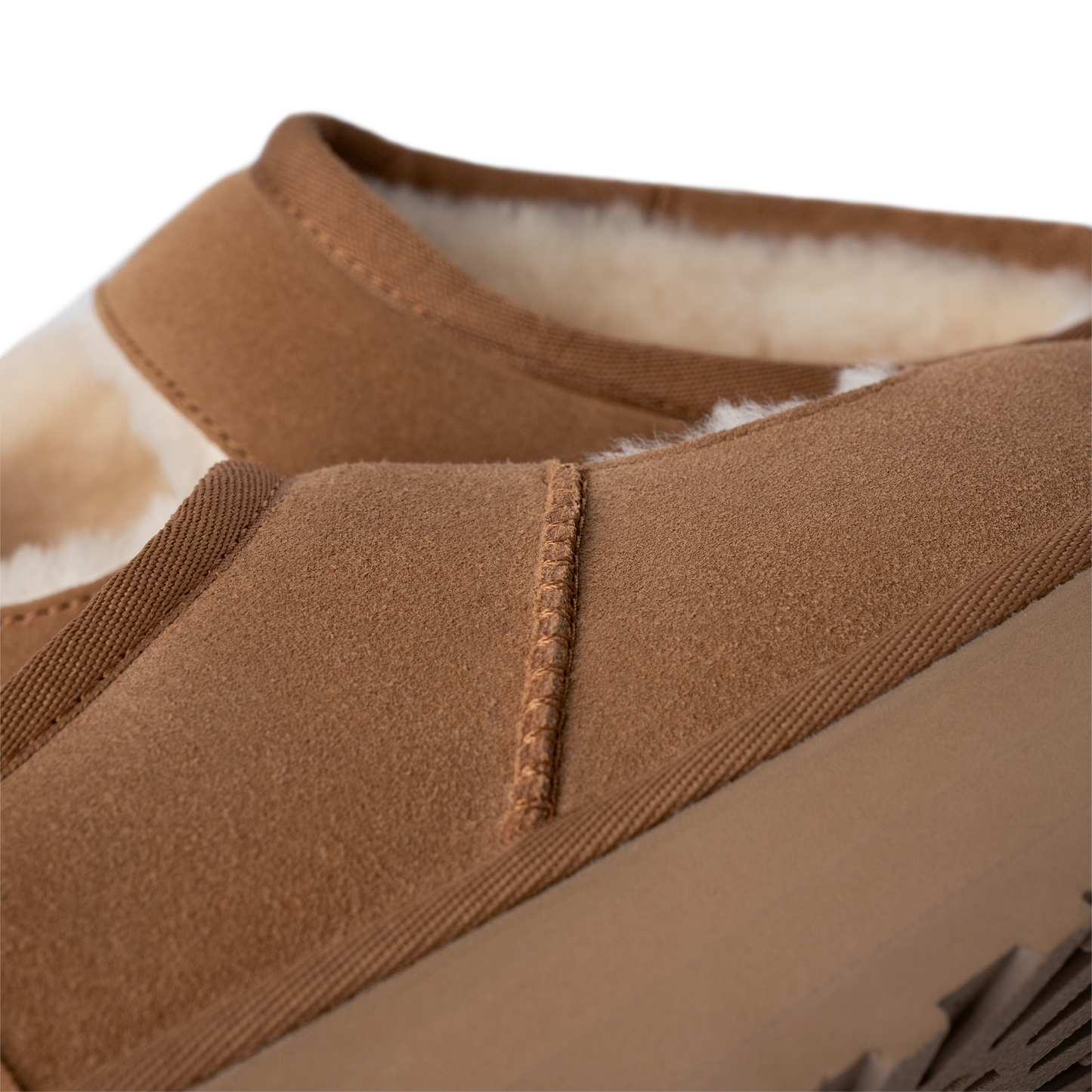 Close-up view of a brown suede slipper with sheepskin lining.