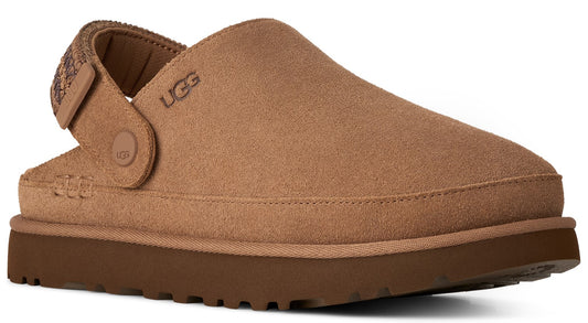 A tan suede slip-on shoe with a thick brown rubber platform sole, featuring an adjustable back strap with a patterned design and the embossed text UGG on the side and the strap attachment.