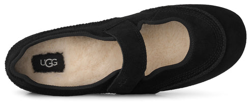 A top-down view of a black Mary Jane-style slip-on shoe with a cream-colored plush lining and a small UGG logo tag on the heel.
