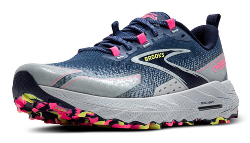 Trail running shoe with a blue and gray upper, pink accents, a white midsole, and a lugged outsole with pink and yellow details.