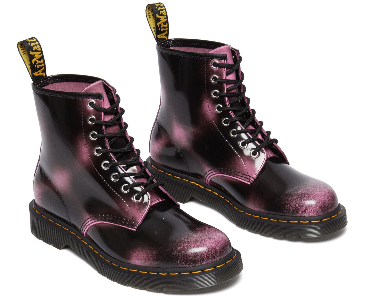 Pair of black ankle-high boots with black laces and light pink accents, featuring yellow pull-loops with "Air Wair" text.
