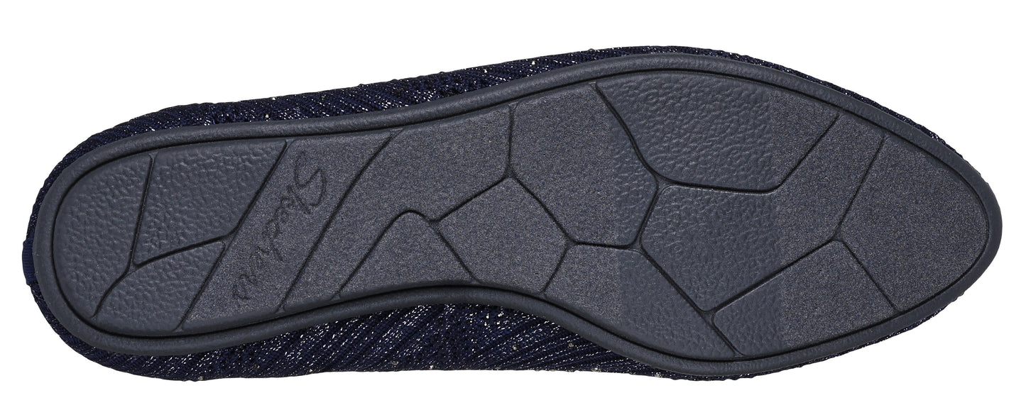 Close-up on the sole of a shoe, revealing a textured, patterned surface divided into geometric shapes.