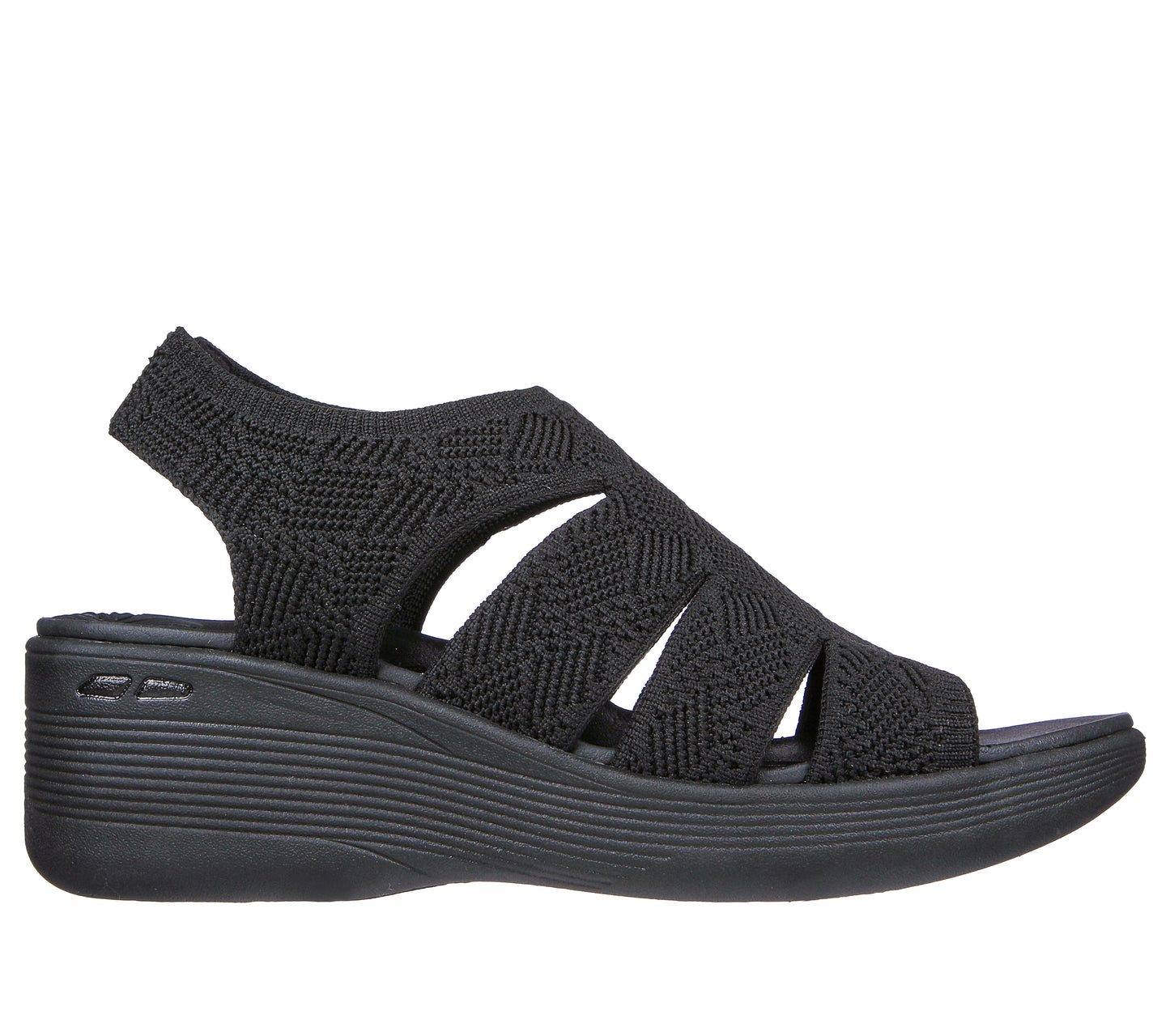 Black sandal featuring a wedge heel, peep toe, zigzag textured fabric, and elasticized slingback strap.