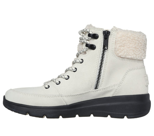 A white ankle boot with a black sole features black eyelets, a white and black shoe lace, a zipper, and a cream-colored shearling lining.