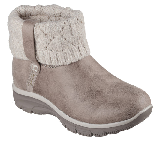 A light brown suede ankle boot with a beige, cable-knit sweater collar and a grey ridged rubber sole, viewed from a side angle.