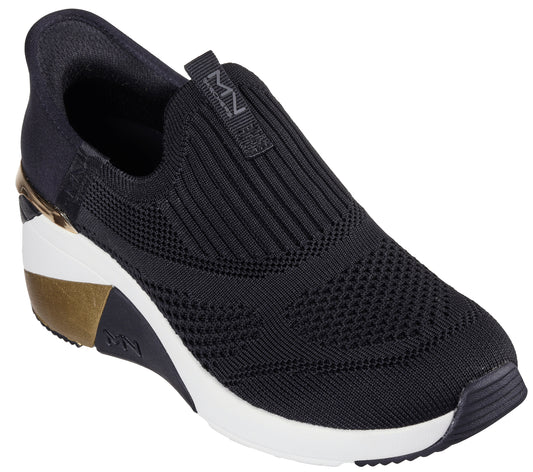 Black slip-on sneaker with black ribbed knit upper and white platform sole featuring gold accents.