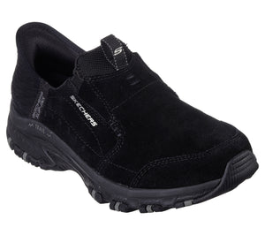 Black slip-on casual shoe with elastic panel at vamp, pull tab on heel, and chunky lug sole. "SKECHERS" is printed on the side.