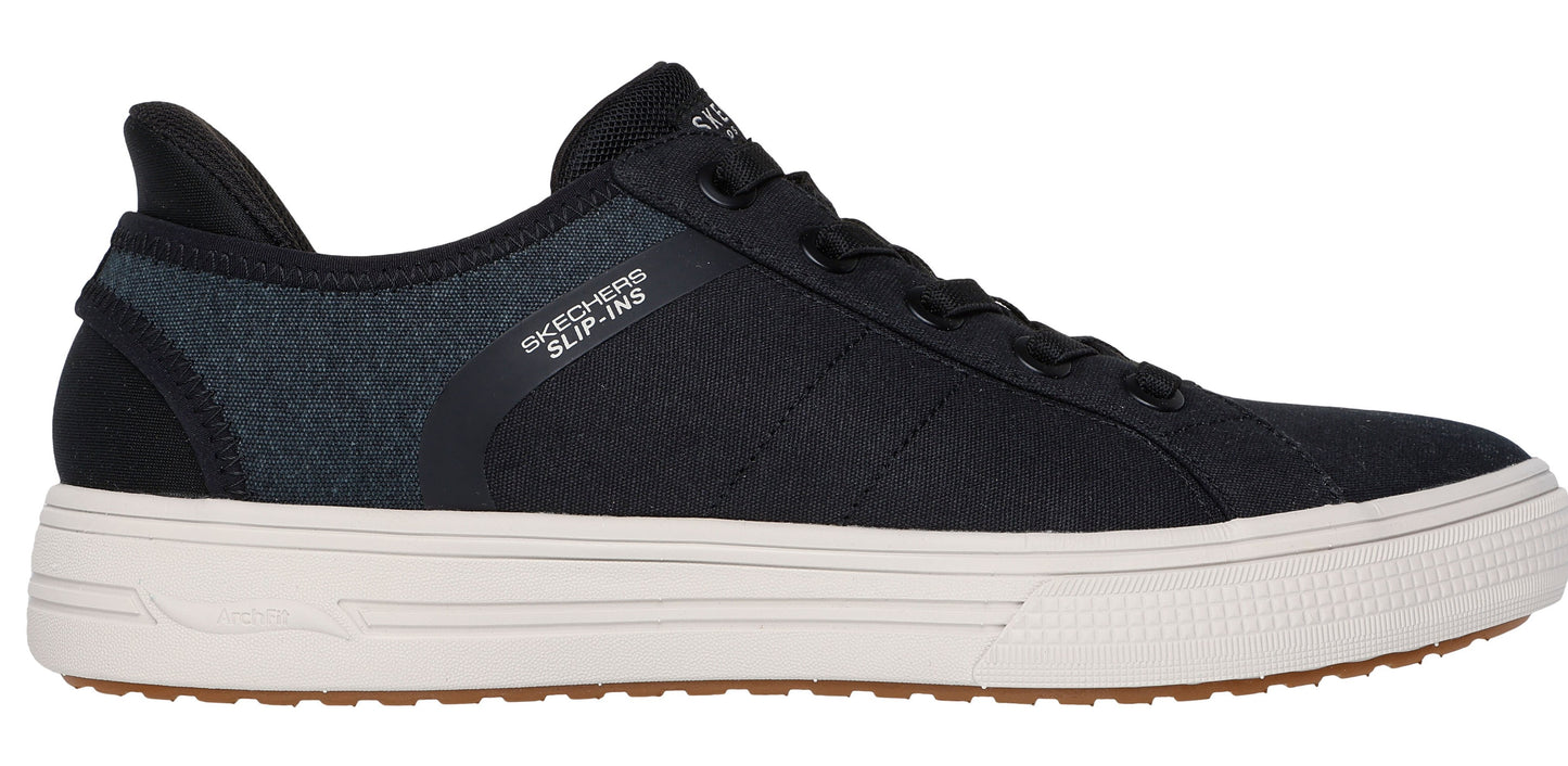 A black slip-on sneaker with a white midsole and a brown outsole.