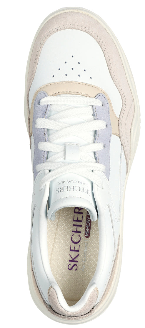 A top-down view of a white sneaker with a suede accent.