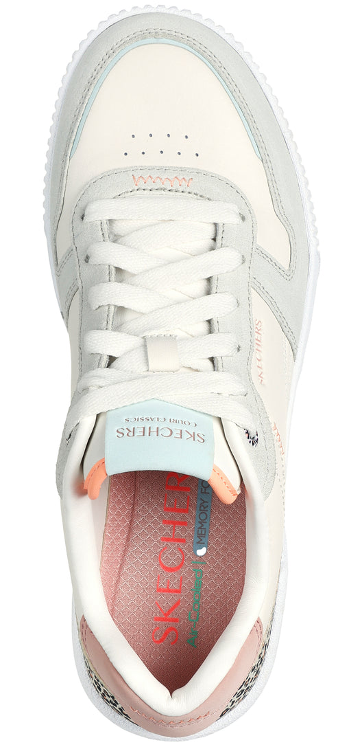 A low top sneaker with white laces, off white color, with a gray and peach colored insole.