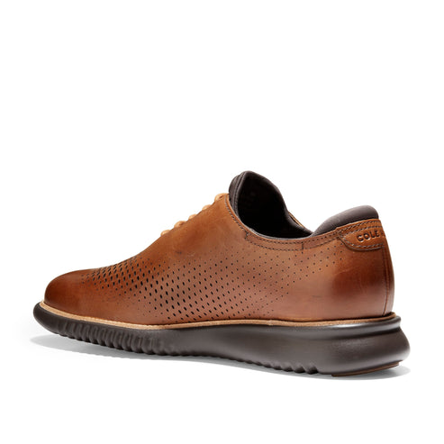 Brown leather perforated dress shoe with brown soles and laces.