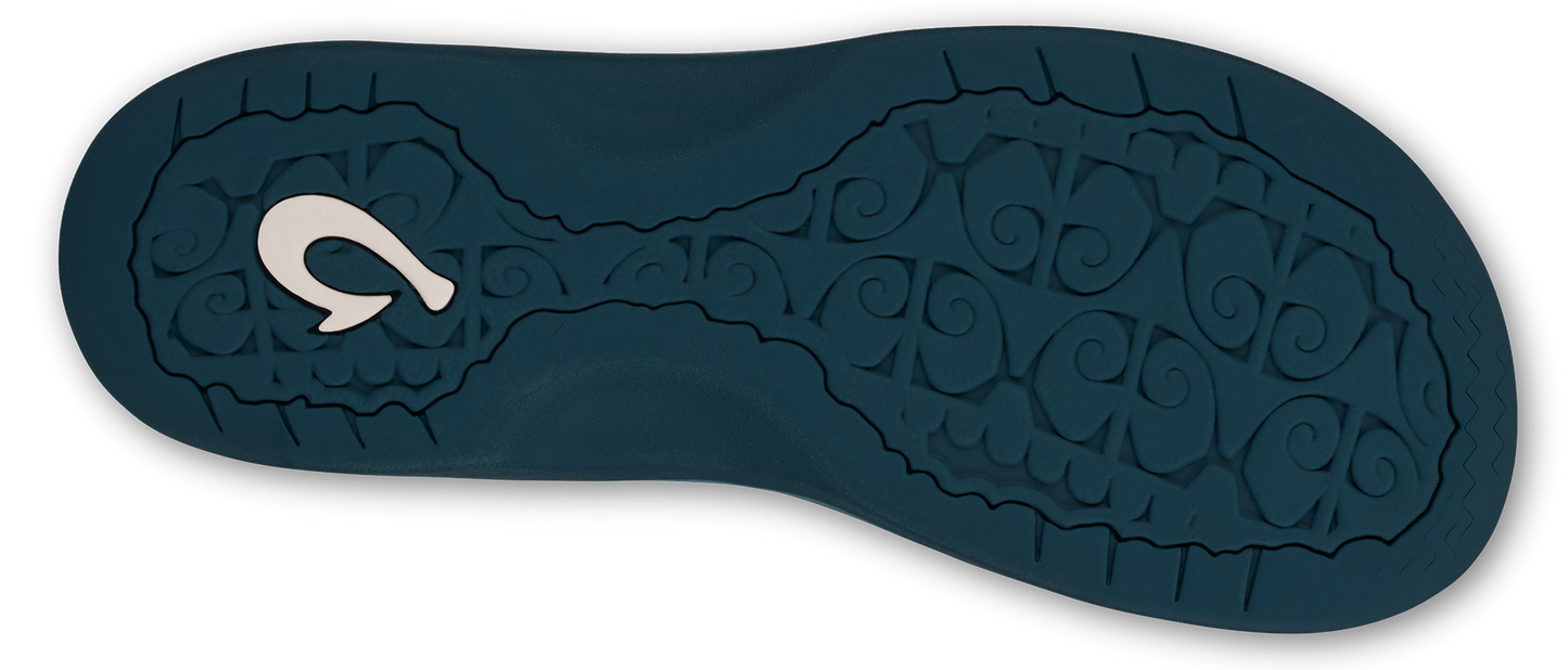 A close-up shows the textured dark blue sole of a sandal with a white hook-shaped design on one end.