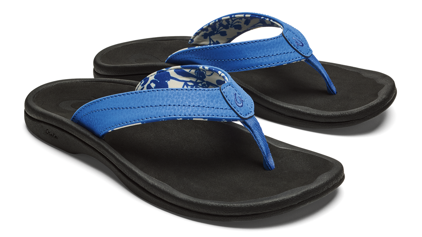 A pair of black flip-flops with blue straps and floral-patterned lining.